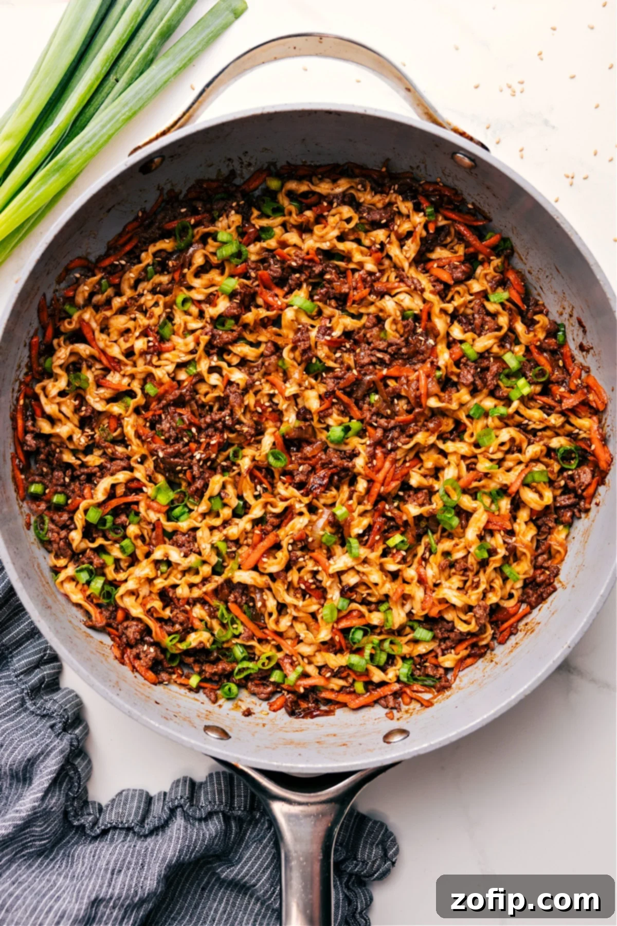 Family Favorite Quick & Easy Beef Noodle Bowls Recipe Beef Noodle Bowls simmering in a pot with noodles, beef, and veggies, ready to be served, showcasing rich colors and inviting steam.