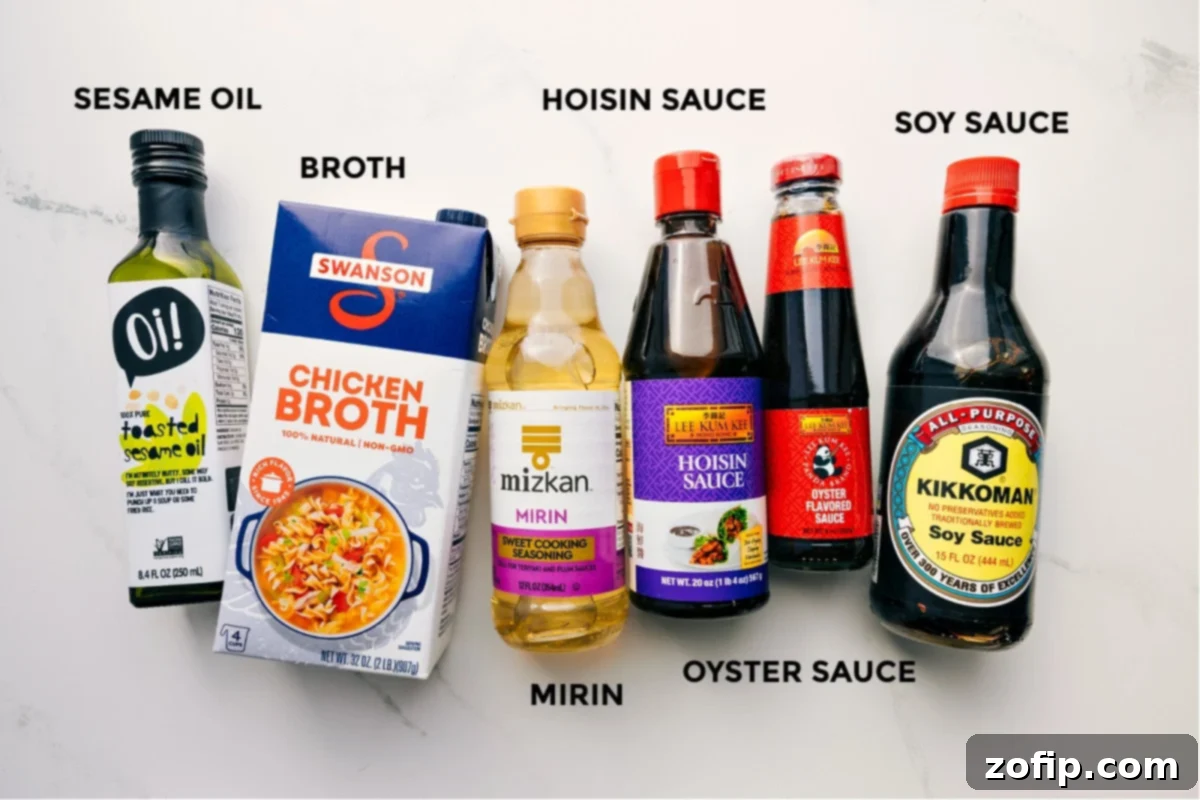 Essential Ingredients for Beef Noodle Bowls The savory sauce ingredients for Beef Noodle Bowls, including sesame oil, broth, hoisin sauce, mirin, oyster sauce, and soy sauce, neatly prepped for mixing.