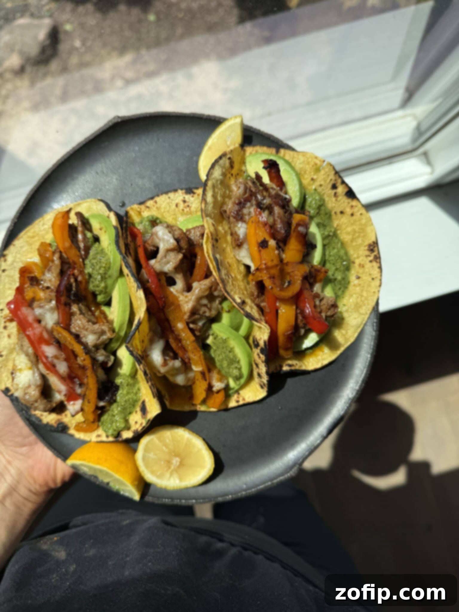 Delectable Shaved Beef Tacos assembled on a plate, featuring colorful toppings.