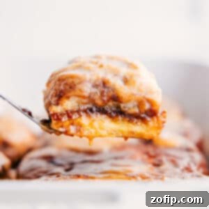 A plate of freshly baked Magic Pumpkin Cinnamon Rolls with creamy glaze, ready to be served.