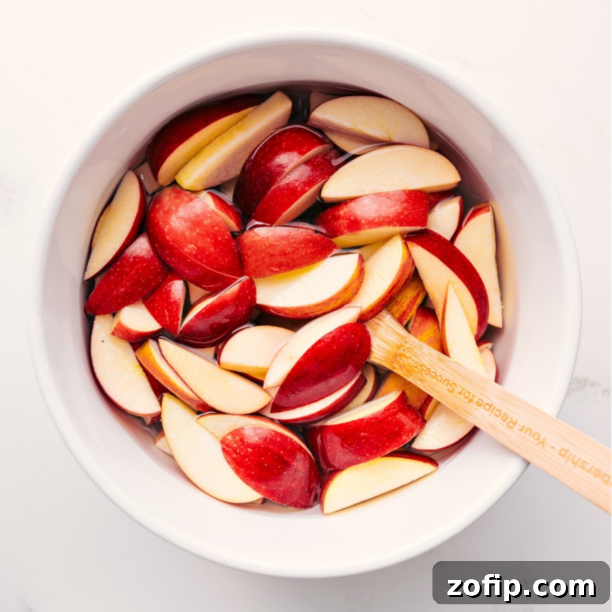 How To Make Caramel Apple Dessert Cups Apple slices soaking in salted water to prevent browning for Caramel Apple Dessert Cups.