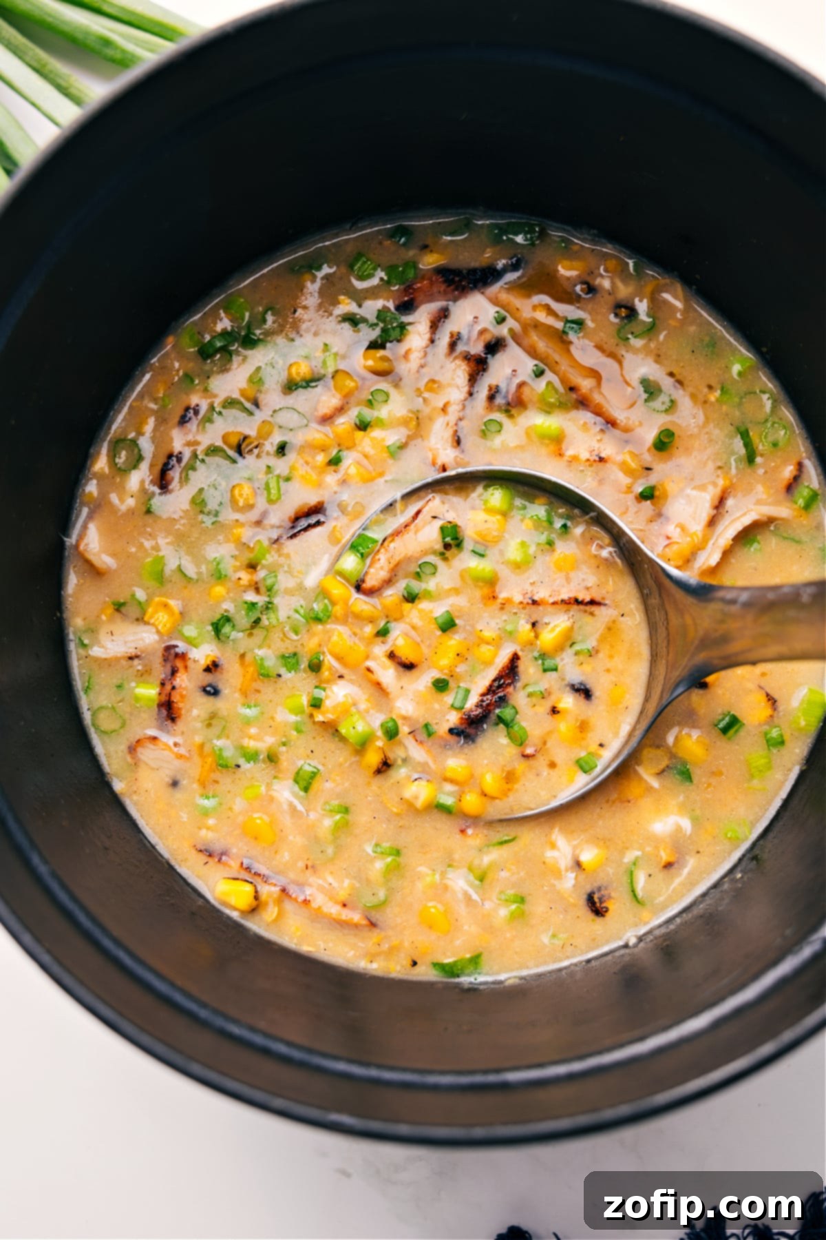 Simple One Pot Chicken Corn Soup Recipe Chicken Corn Soup Recipe in a pot with a ladle scooping some out, highlighting its creamy texture and rich ingredients.