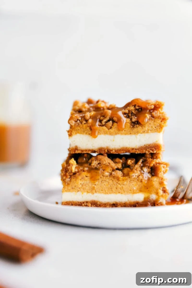 Simple & Delicious Pumpkin Spice Cheesecake Bars Recipe Decadent pumpkin spice cheesecake bars, elegantly stacked and drizzled with luscious caramel, perfect for fall gatherings.