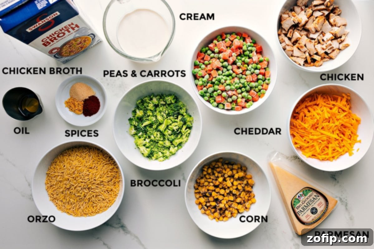 Assortment of fresh and frozen ingredients prepped and arranged for making chicken orzo bake, including chicken broth, heavy cream, olive oil, spices, frozen peas and carrots, corn, fresh broccoli, shredded cheddar, grated Parmesan, and dry orzo pasta.