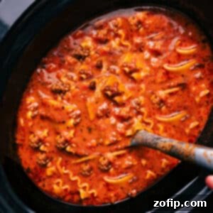 A savory bowl of Crockpot Lasagna Soup, garnished with fresh basil and a dollop of creamy cheese, ready to be served.