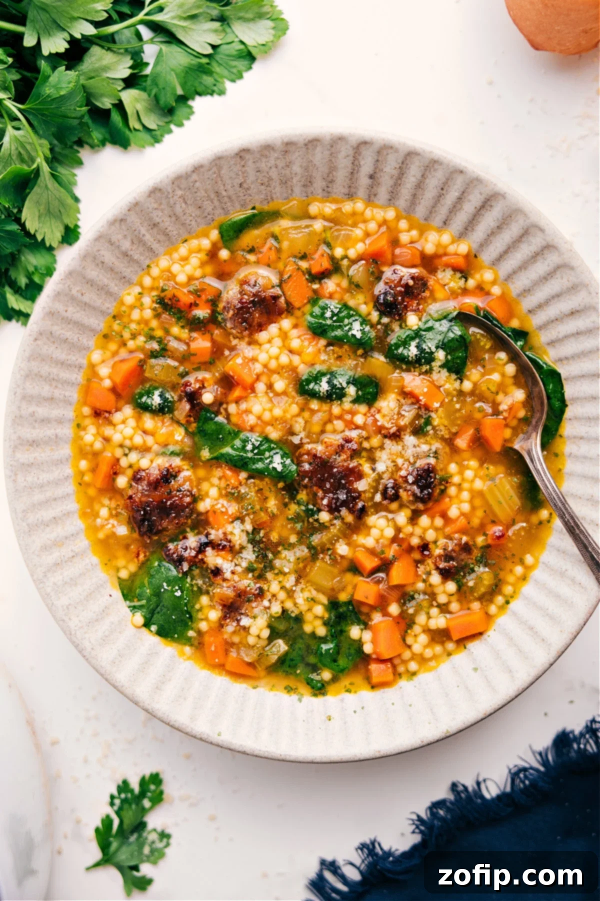 The Ultimate Comfort Food: Italian Wedding Soup Recipe A steaming bowl of homemade Italian Wedding Soup, garnished with fresh parsley and grated Parmesan cheese, with a spoon ready for tasting.