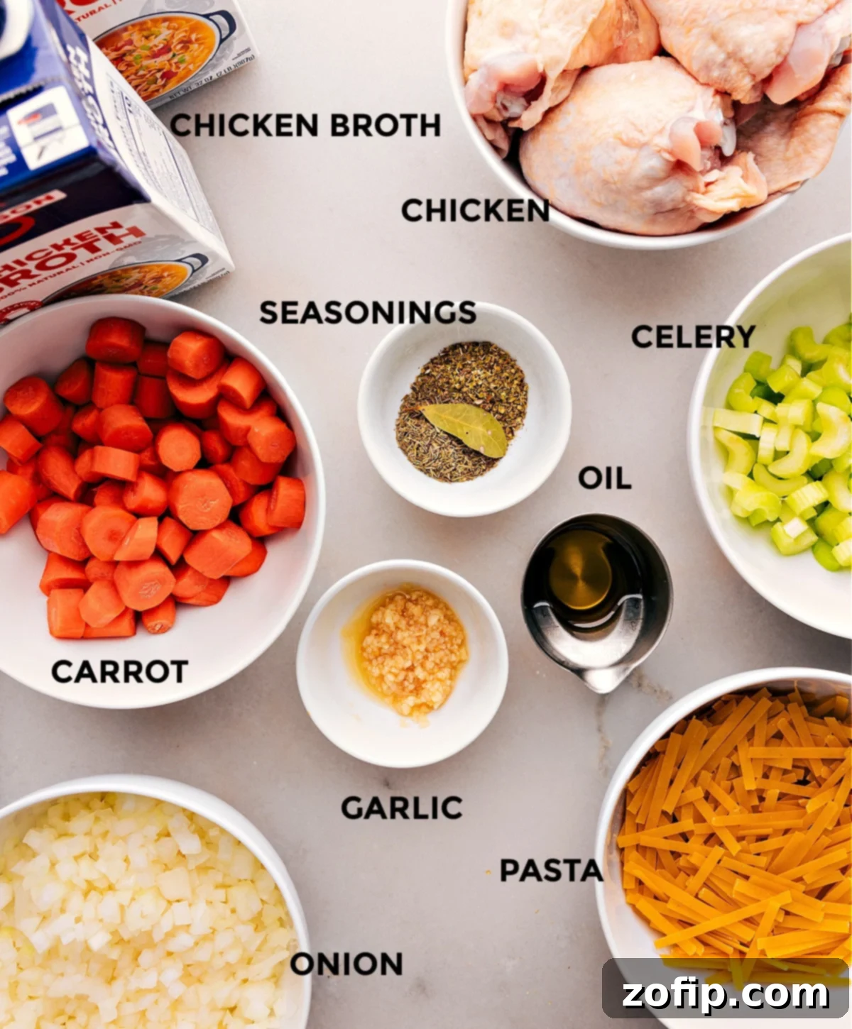 Essential Ingredients for the Best Chicken Noodle Soup All the fresh, vibrant ingredients used in this chicken noodle soup recipe, neatly spread out on a wooden cutting board.