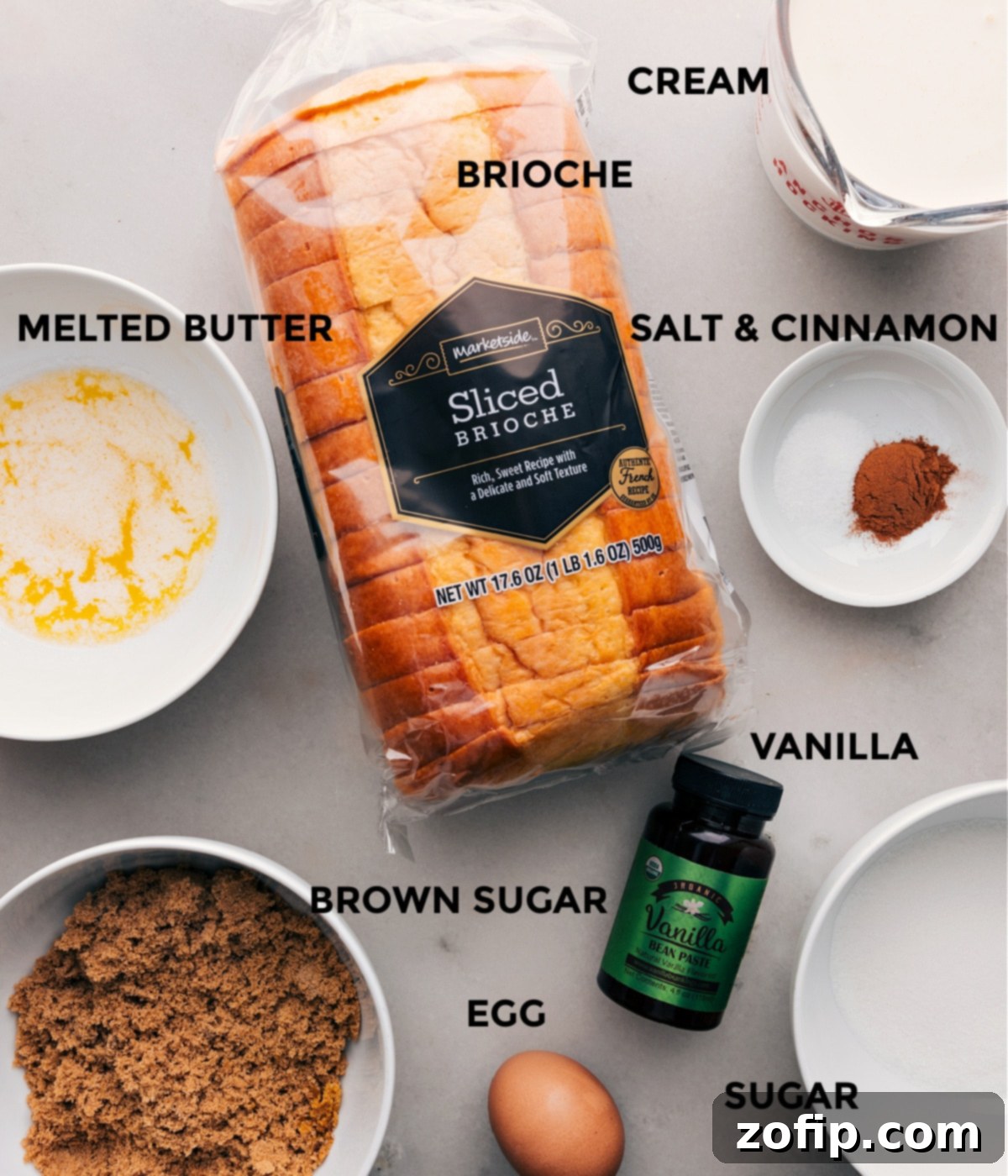 A vibrant display of fresh ingredients for a classic bread pudding recipe, including golden brioche bread slices, a bowl of rich melted butter, both brown and granulated sugars, fresh eggs, heavy cream, and a bottle of vanilla extract, artfully arranged on a wooden countertop.
