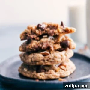 Close-up of a Cowboy Cookie, showcasing its chewy texture, melted chocolate, and visible oats, pecans, and coconut.