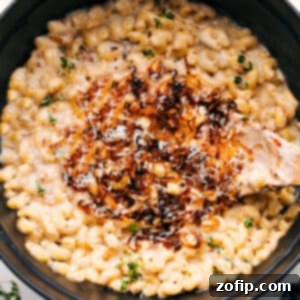 A bowl of French Onion Mac And Cheese with a spoon