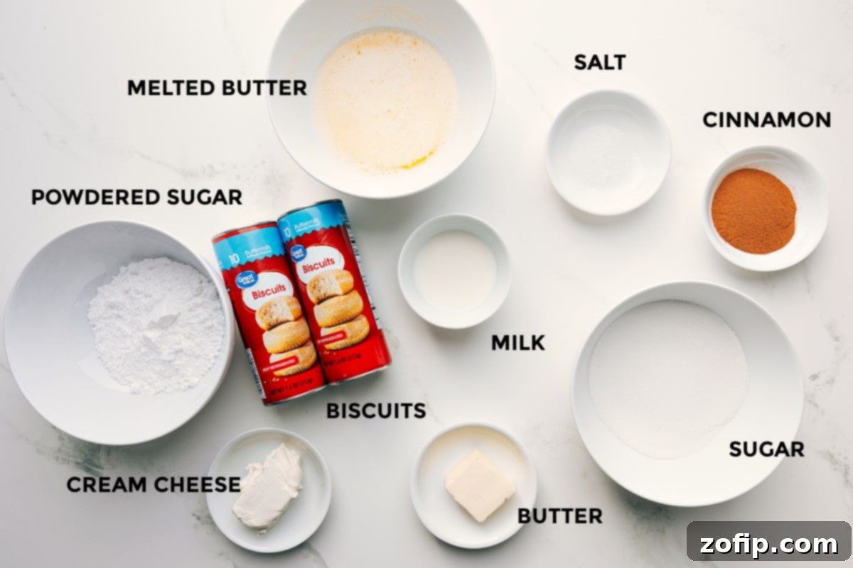 All the essential ingredients for making a quick Cinnamon Roll Cake, neatly laid out: powdered sugar, cream cheese, melted butter, ready-to-bake biscuits, milk, butter, salt, cinnamon, and granulated sugar.