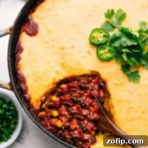 A top-down view of the golden-brown cornbread casserole in a skillet, showcasing its inviting texture and hearty appearance, ready to be served.
