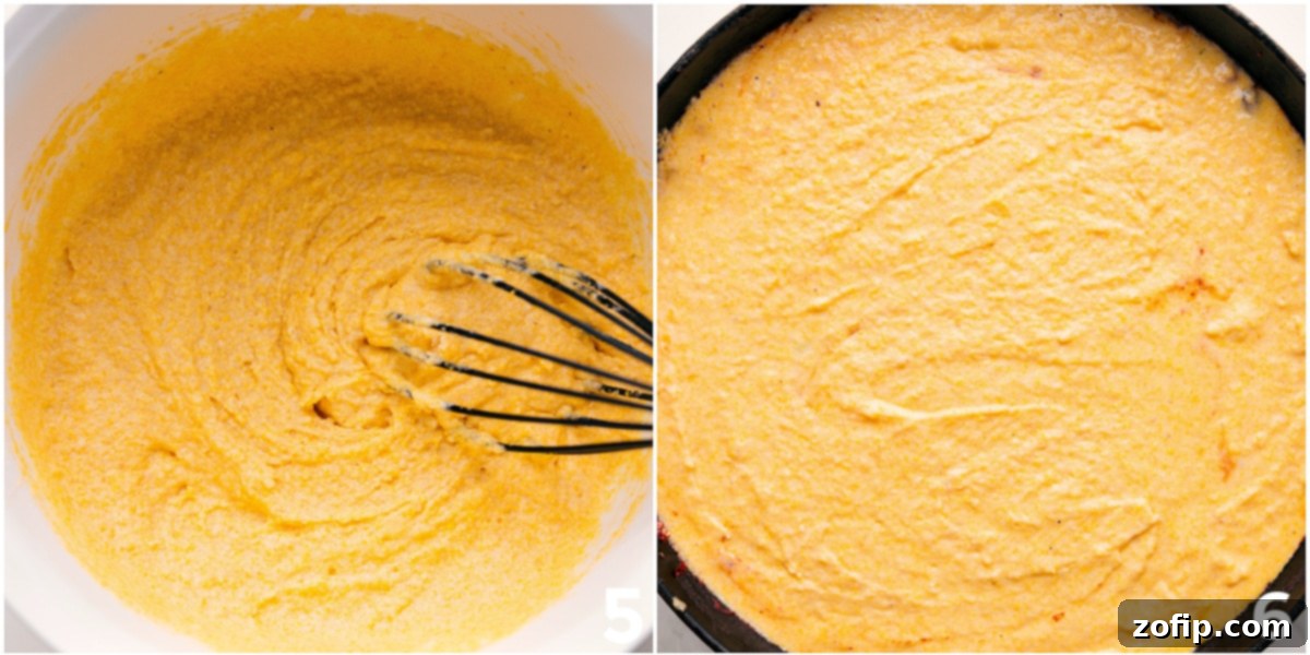 Fluffy cornbread batter being poured and gently spread over the simmering chili in a skillet, preparing the cornbread casserole for baking to achieve a perfectly golden and tender topping.