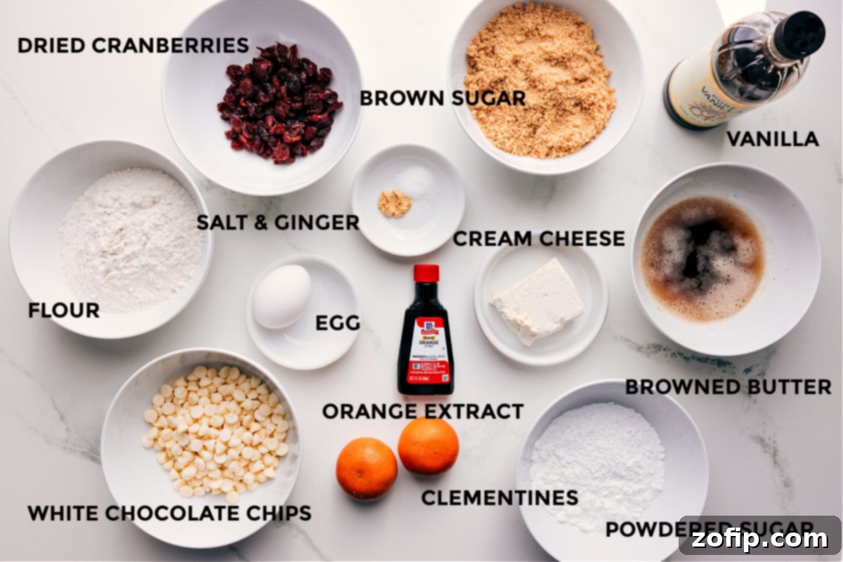 All the ingredients for Cranberry Bliss Bars recipe prepped out for easy assembly including flour, cranberries, white chocolate chips, brown sugar, salt, ginger, egg, orange extract, clementines, cream cheese, powdered sugar, browned butter, and vanilla.