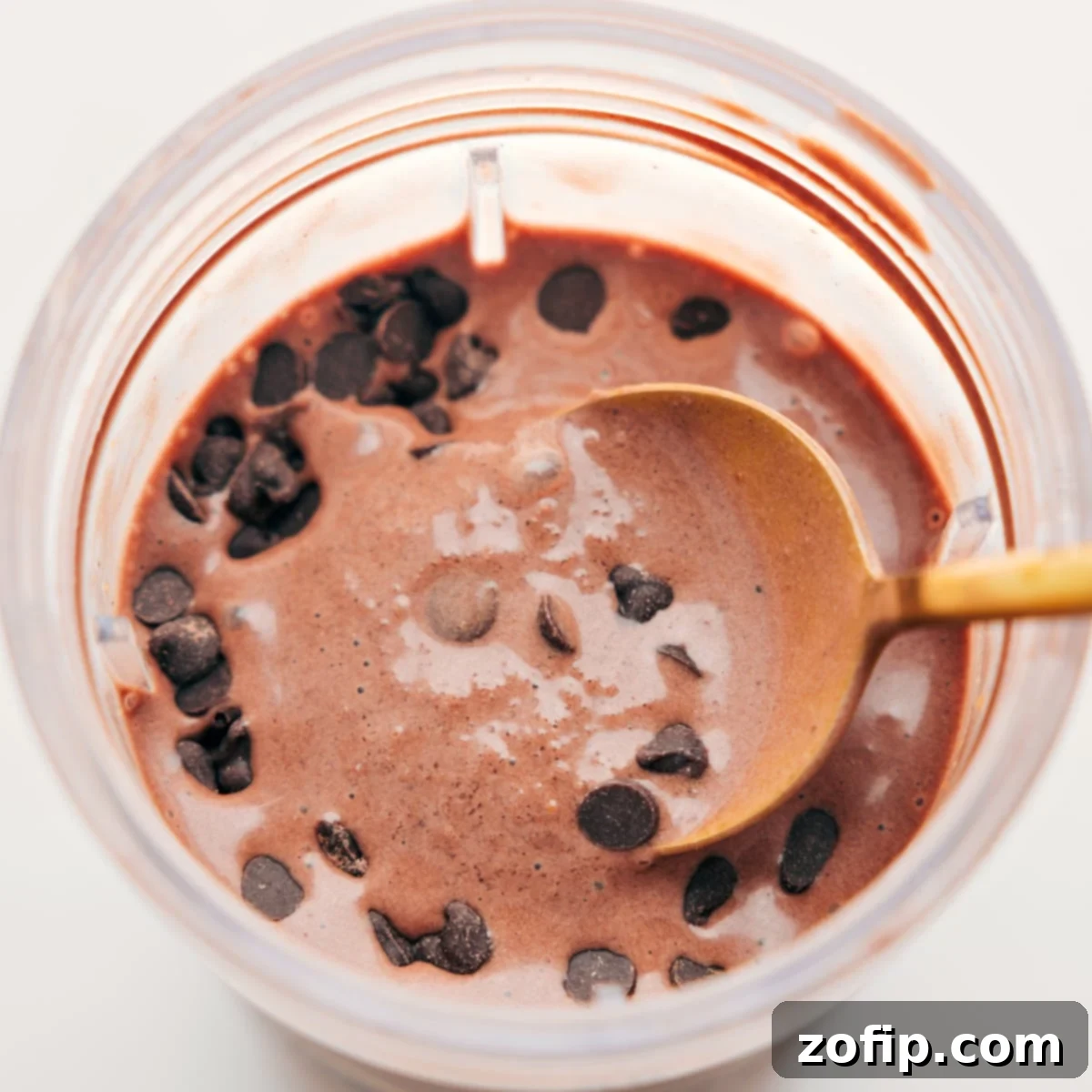 Spoonful of the delicious and creamy chocolate protein shake with chocolate chips on top for an extra delicious treat.