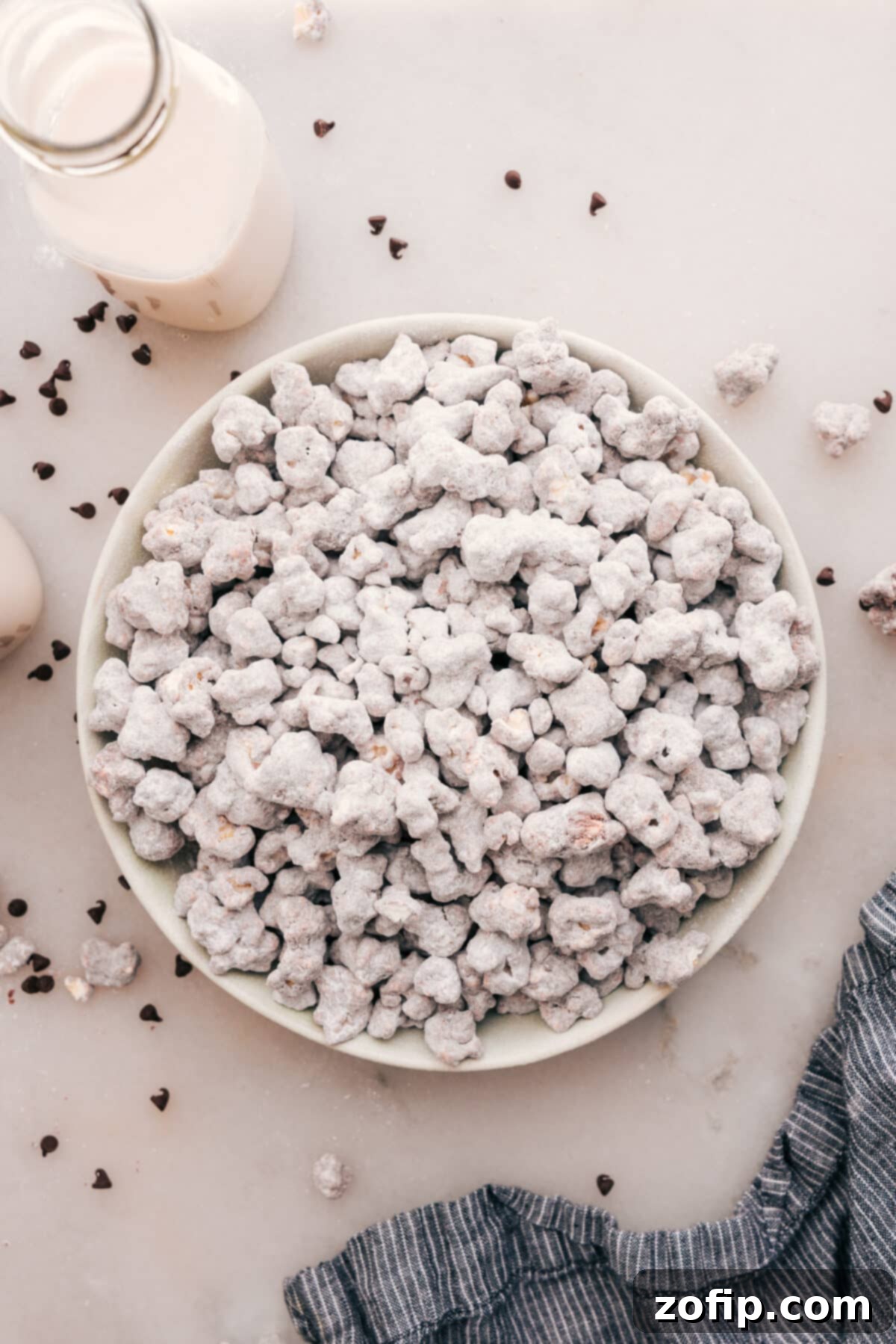 A large bowl brimming with freshly made Popcorn Puppy Chow, coated in chocolate, peanut butter, and powdered sugar, ready for snacking.