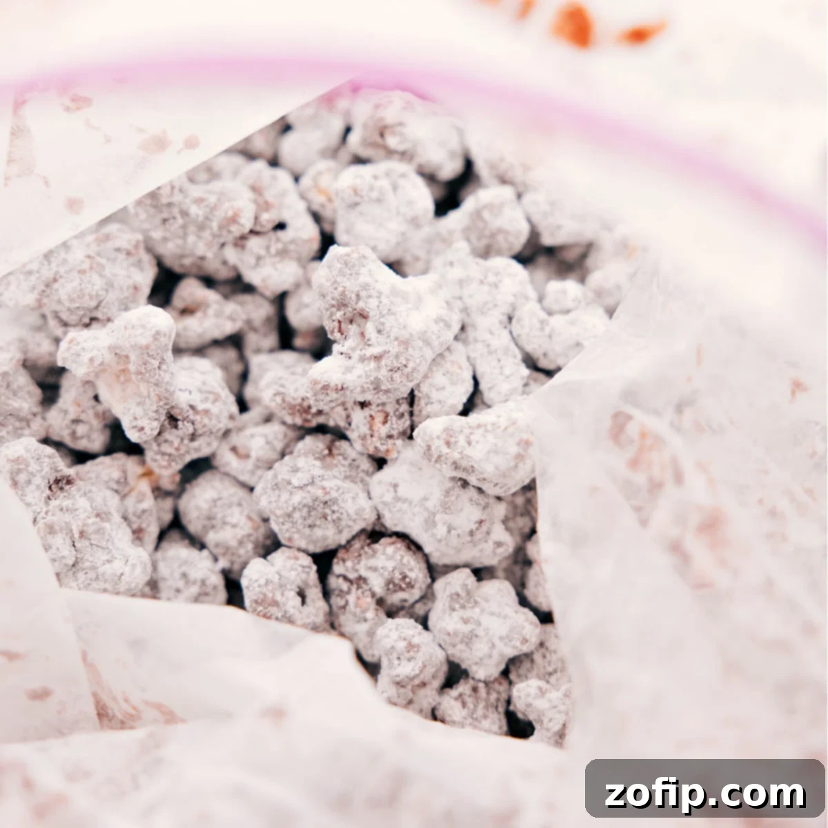 Coated popcorn being tossed in a large resealable bag with powdered sugar, creating the classic 'muddy buddy' finish for Popcorn Puppy Chow.