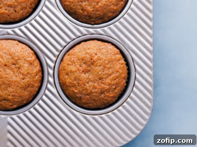 Freshly baked Carrot Cake Cupcakes cooling in a muffin pan.