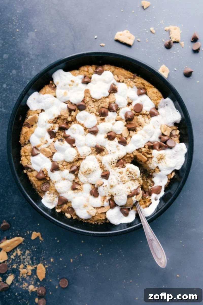 Freshly baked S'mores Pizookie, warm and gooey, topped with melted marshmallows and chocolate, inviting a sweet dessert indulgence.