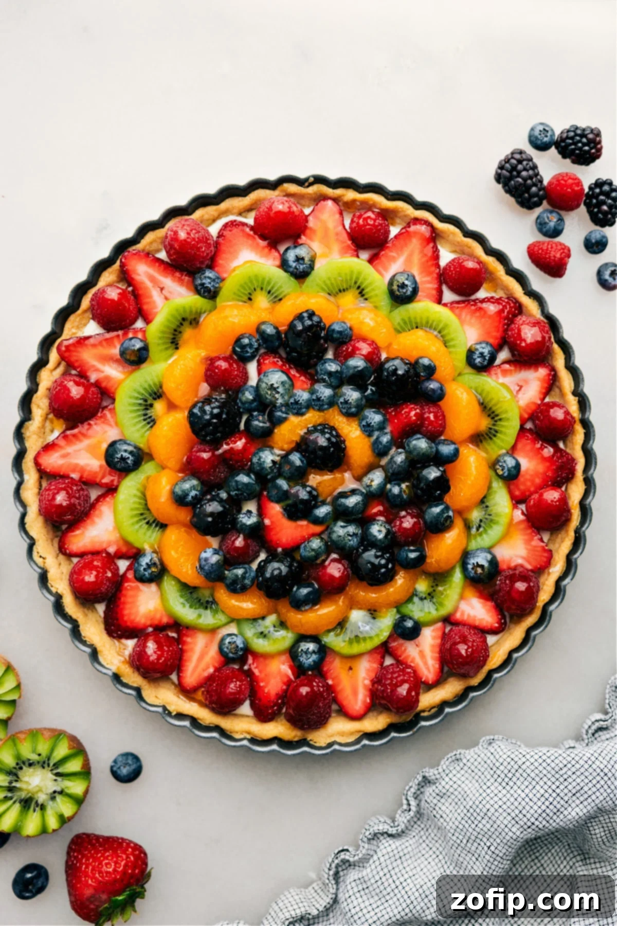 The Best Fruit Pizza Recipe: Sugar Cookie Crust, Cream Cheese Frosting, and Fresh Fruit Delicious Fruit Pizza Recipe with a sweet glaze, ready to be sliced and enjoyed as the perfect summer dessert.