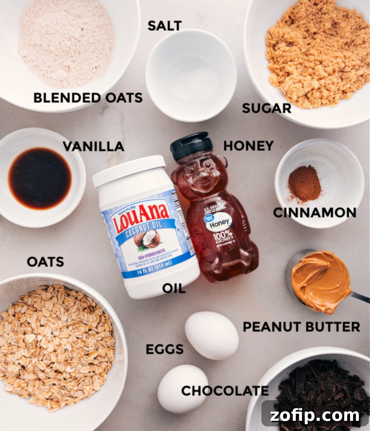 Wholesome Ingredients For Homemade Oatmeal Breakfast Bars All the essential ingredients for Soft-Baked Oatmeal Breakfast Bars laid out: oats, oat flour, cinnamon, salt, peanut butter, coconut oil, honey, brown sugar, vanilla, eggs, and dark chocolate chips.