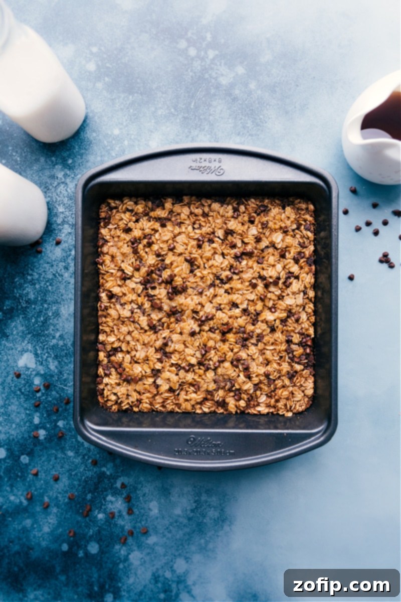 Sliced Chocolate Chip Baked Oatmeal in a pan, ready to be served, with a hint of a topping.