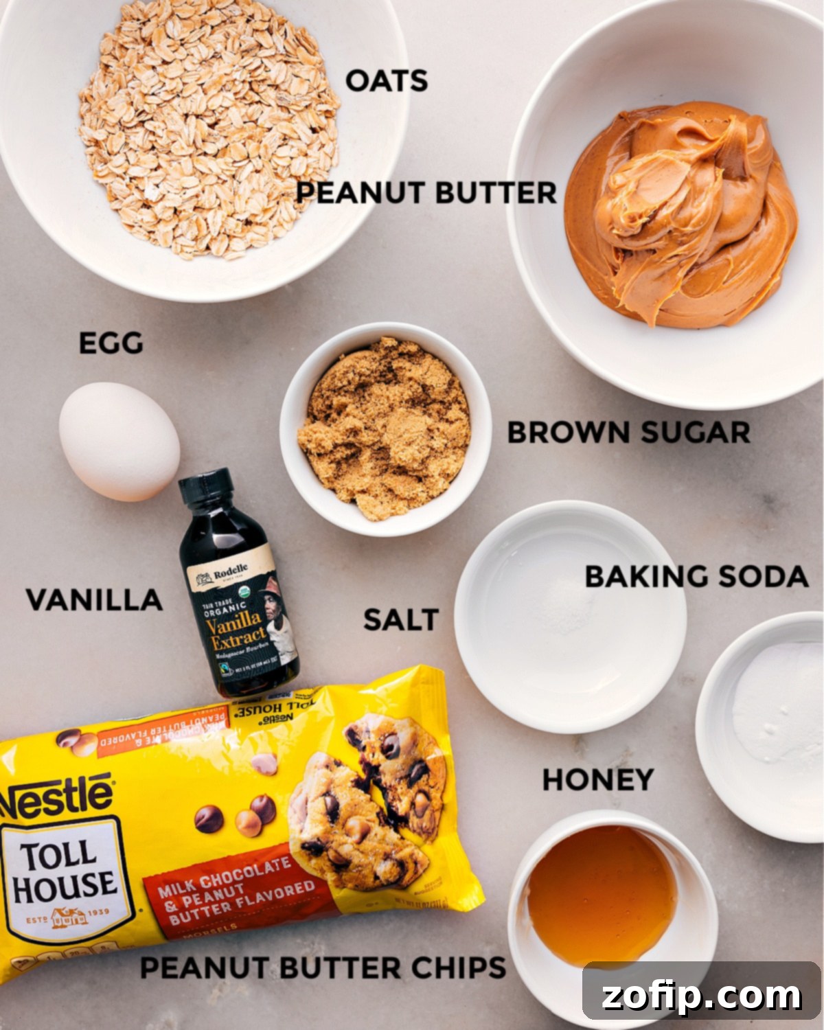 Key Ingredients for Healthy Peanut Butter Oat Cookies A collection of all necessary ingredients, meticulously prepped and laid out for easy assembly of healthy breakfast cookies, including old-fashioned oats, creamy peanut butter, brown sugar, honey, baking soda, salt, vanilla extract, a large egg, and peanut butter chocolate chips.