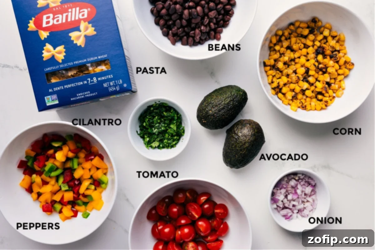 All the vibrant ingredients prepped and arranged for easy assembly: cooked pasta, canned black beans, sweet corn, creamy avocado, crisp red onion, juicy tomatoes, fresh cilantro, and colorful bell peppers.