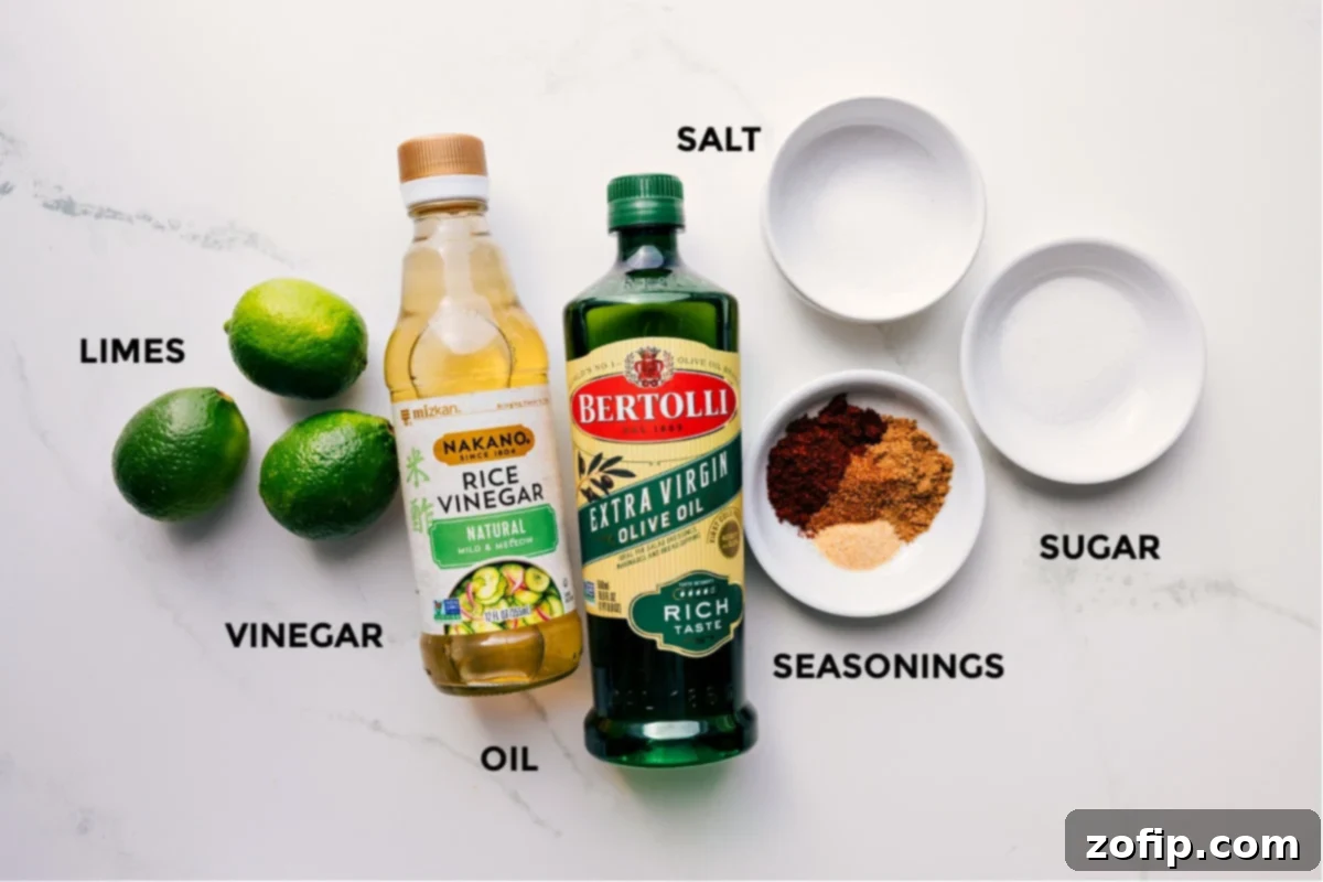 All the vibrant ingredients for the Mexican Pasta Salad dressing, including fresh limes, rice vinegar, olive oil, granulated sugar, garlic powder, ground chili powder, cumin, cayenne pepper, and salt.