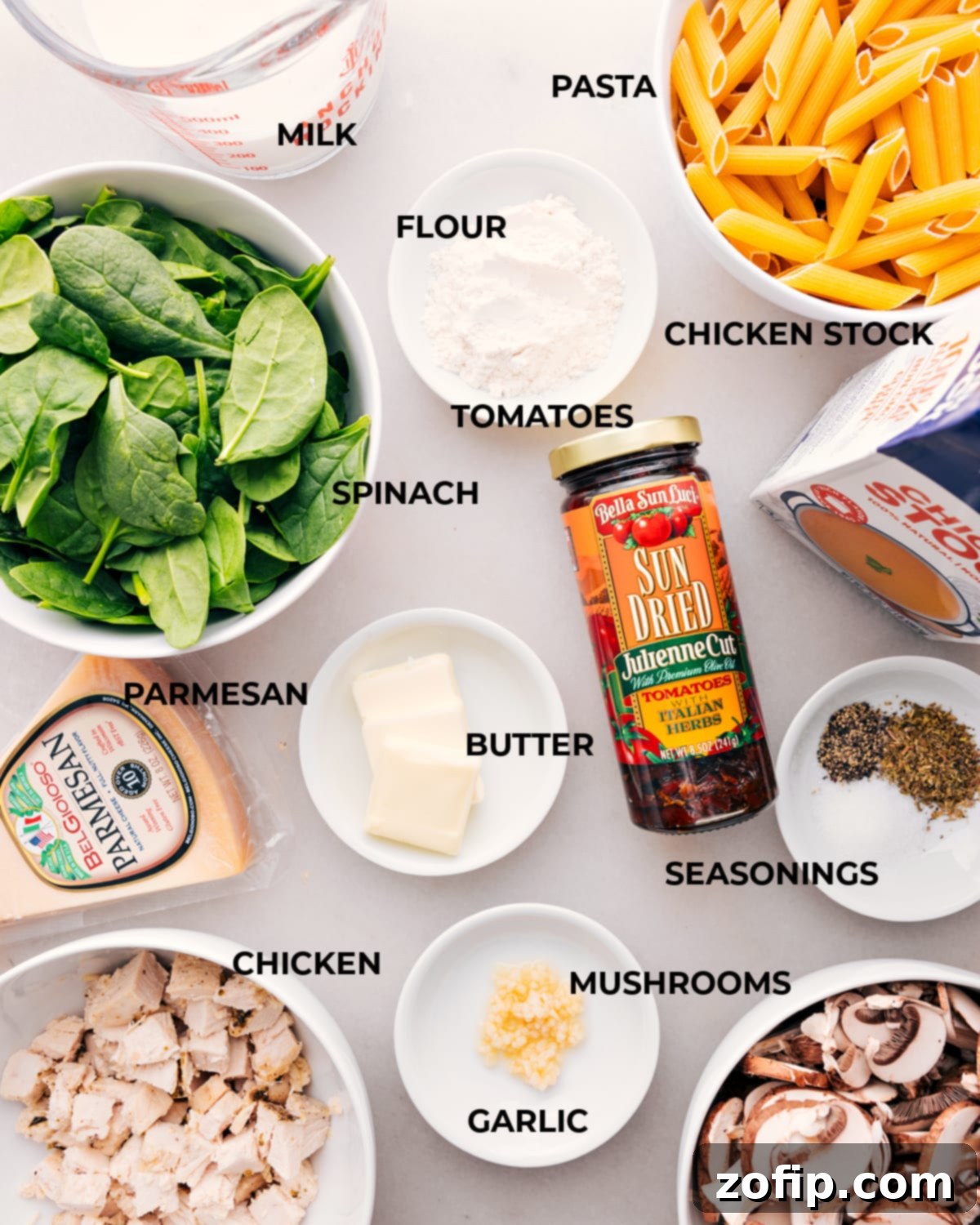 Pre-measured Ingredients for Chicken Penne Pasta Recipe Ingredients for Chicken Penne Pasta, including measured portions of chicken, penne, cheese, sun-dried tomatoes, mushrooms and spinach, are neatly laid out.