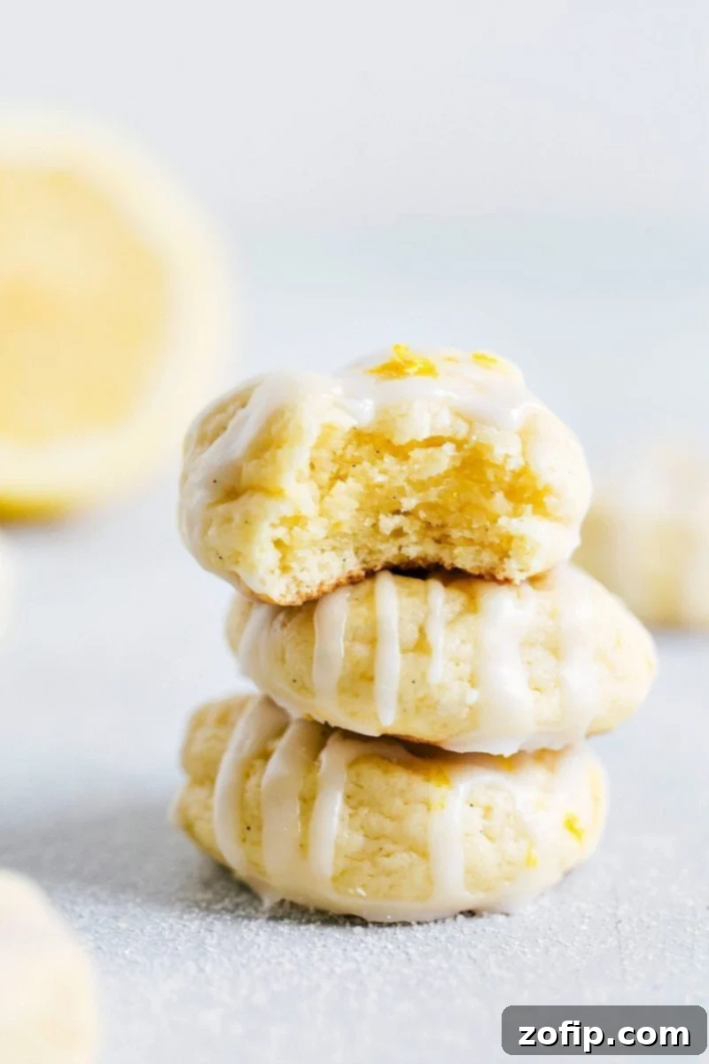 A close-up of a beautifully glazed lemon cheesecake cookie, sweet and zingy, ready to be enjoyed. The soft texture and vibrant glaze are clearly visible.