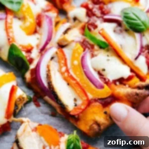 Two freshly baked flatbread pizzas on a baking sheet, one with a slice being removed.