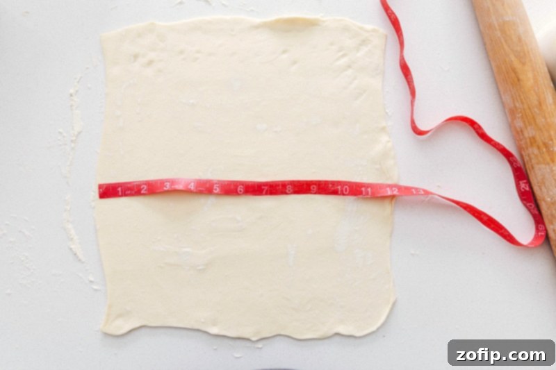 Puff pastry sheets rolled out and cut into squares, ready for filling.