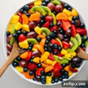 My Go-To Fruit Salad 2 The easy fruit salad recipe in a bowl with serving spoons.
