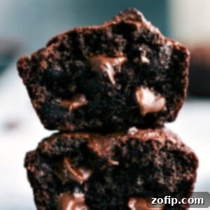 Chocolate peanut butter muffins, cut in half and stacked, revealing their soft interior with gooey chocolate chips.