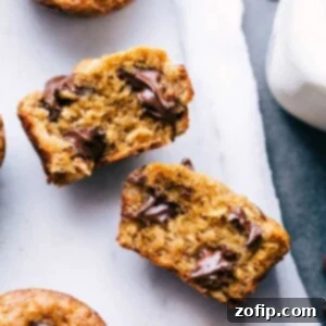 Peanut butter banana muffin broken open, revealing the delicious interior with melting chocolate chips.