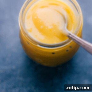 Creamy Lemon Bliss 2 A close-up of vibrant homemade Lemon Curd in a jar with a spoon.