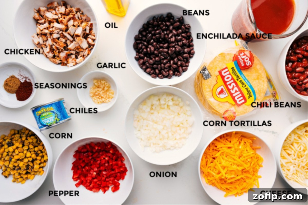All the essential ingredients for Chicken Enchilada Casserole, perfectly prepped and neatly arranged for assembly, including cooked chicken, aromatic seasonings, sweet corn, colorful bell peppers, mild green chiles, minced garlic, olive oil, hearty beans, rich enchilada sauce, chili beans, corn tortillas, diced onion, and shredded cheese.