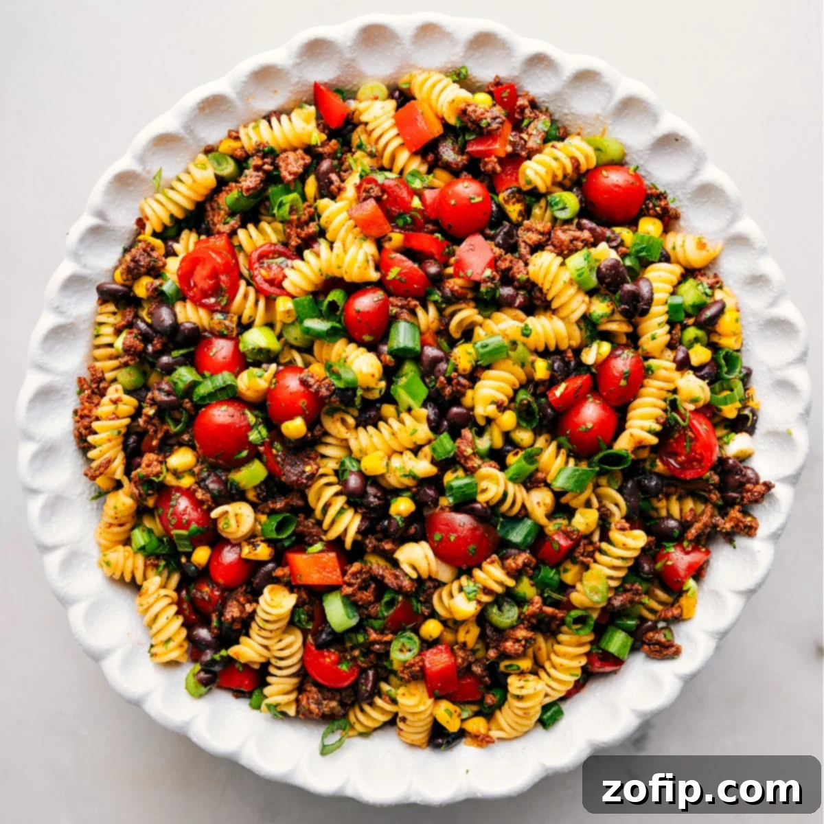 The finished Taco Pasta Salad in a beautiful serving bowl, tossed with the creamy dressing and ready to be enjoyed at a gathering.