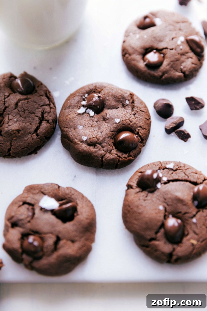 Close-up of freshly baked healthy chocolate cookies, perfectly round with melted dark chocolate chips and a sprinkle of sea salt.
