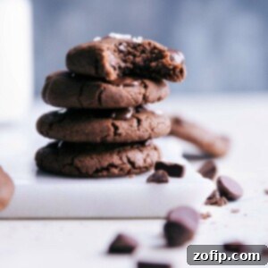 Healthy chocolate chip cookies stacked, with one bitten, showcasing rich chocolate and chewy texture.