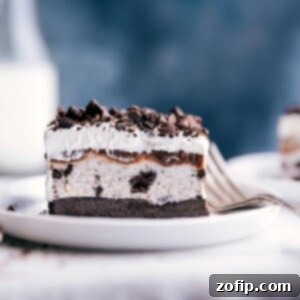 Ultimate Oreo Ice Cream Cake 4 Slice of Oreo ice cream cake with distinct creamy and cookie layers on a plate ready to be enjoyed.