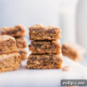A close-up of a perfectly baked Peanut Butter Banana Bar, showing its moist texture, rich color, and the subtle glint of peanut butter chips. A healthy, wholesome dessert or snack.