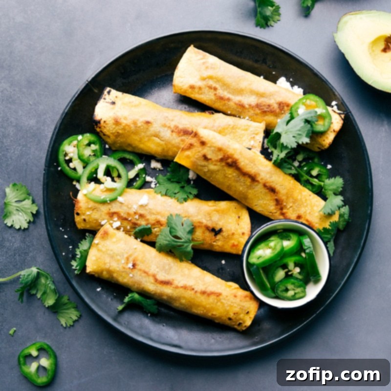 Crispy pork taquitos garnished with fresh cilantro and jalapeños, presenting a flavor-packed meal.