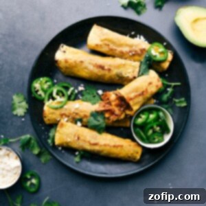 Finished crunchy pork taquitos on a plate, accompanied by sliced jalapeños, cilantro, and avocado on the side.