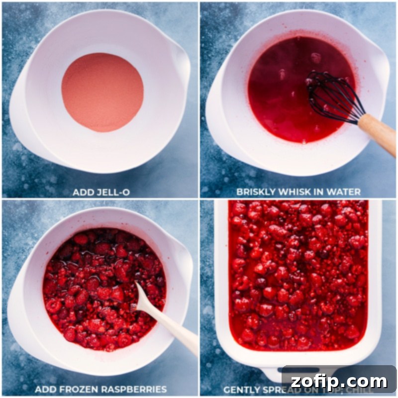 Final process shot showing the Raspberry Jello mixture with frozen raspberries being poured over the cheesecake layer.