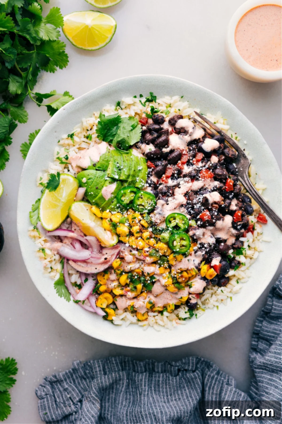 Black Bean Burrito Bowls ready to be enjoyed with fresh toppings and a vibrant sauce.