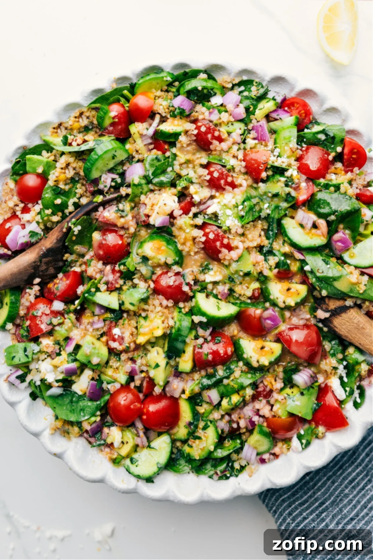 A vibrant Quinoa Salad fully dressed and tossed in a large bowl, showcasing fluffy quinoa, colorful fresh vegetables, and a light dressing, ready to be served and enjoyed.