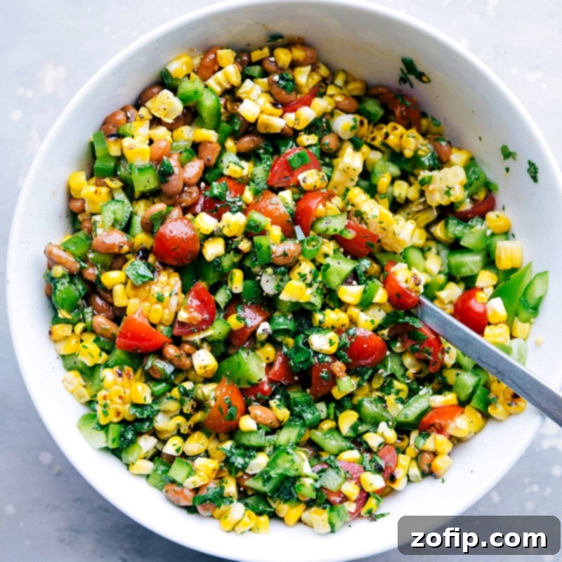 A vibrant bowl filled with flavor-packed corn salsa, which serves as a delightful and refreshing side for this meal, featuring a beautiful blend of fresh ingredients.