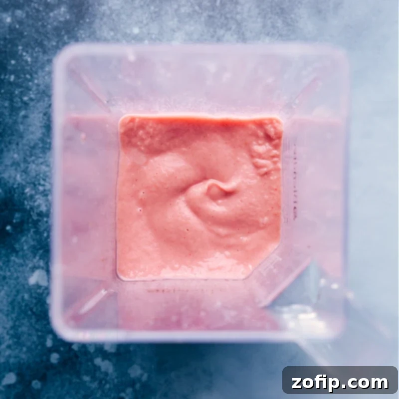 Jamba Juice copycat Strawberry Wild smoothie recipe! Recipe via ChelseasMessyApron #breakfast #quick #easy #simple #best #healthy #dessert #ice #jambajuice #strawberry #wild #smoothie Overhead view of the finished Jamba Juice Strawberry Wild smoothie, still in the blender jar, ready to be poured